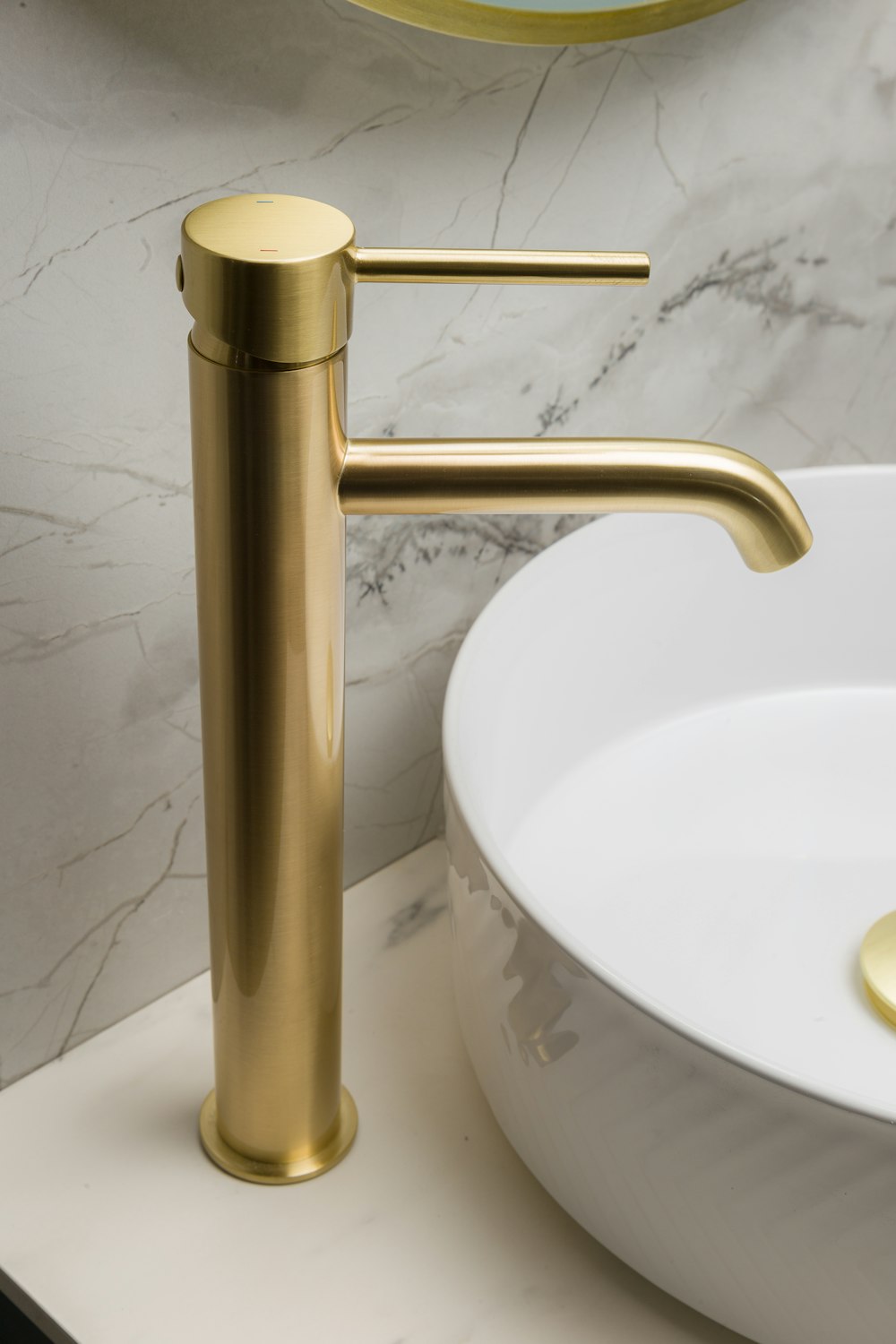 Foto Un lavabo de baño con un grifo dorado junto a un tazón blanco – Imagen  Irlanda gratis en Unsplash