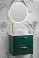 A bathroom vanity mirror framed in brushed metal, glowing softly with warm LED lights.
