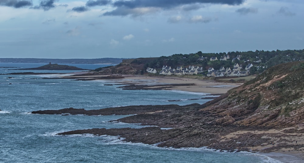 a view of a beach with houses on the shore