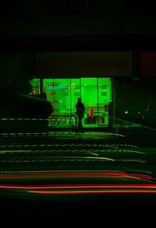 Urban night scene with a model showcasing Green Wave apparel under soft green lighting.
