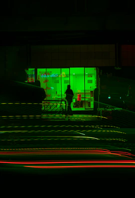 Night view of the store’s exterior illuminated by neon green signage.