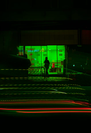 Urban night scene with a model showcasing Green Wave apparel under soft green lighting.