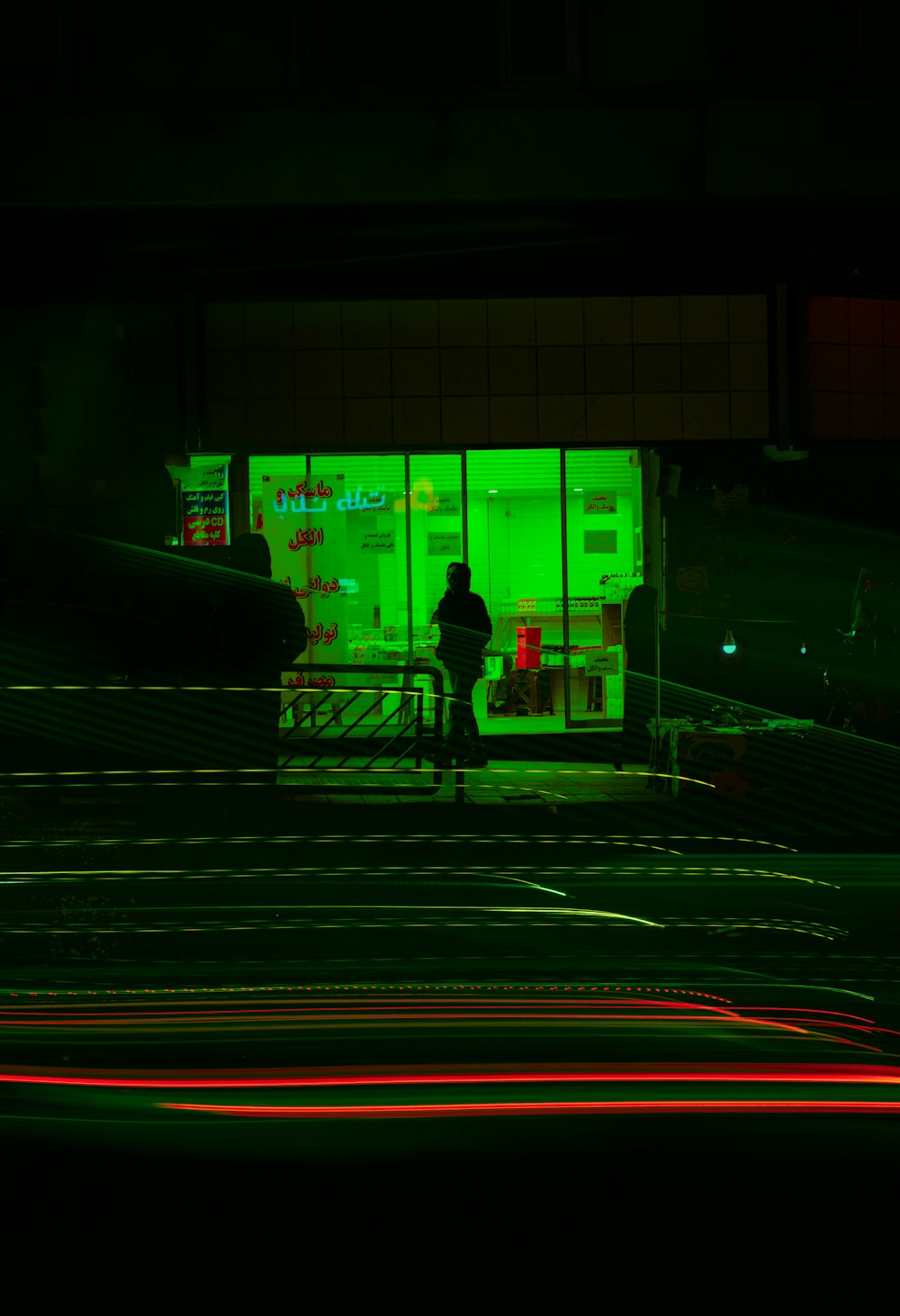 a person standing in front of a store at night