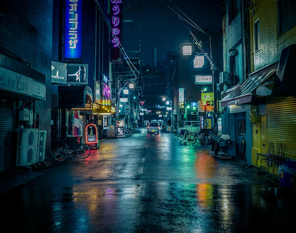 a wet city street at night with neon signs