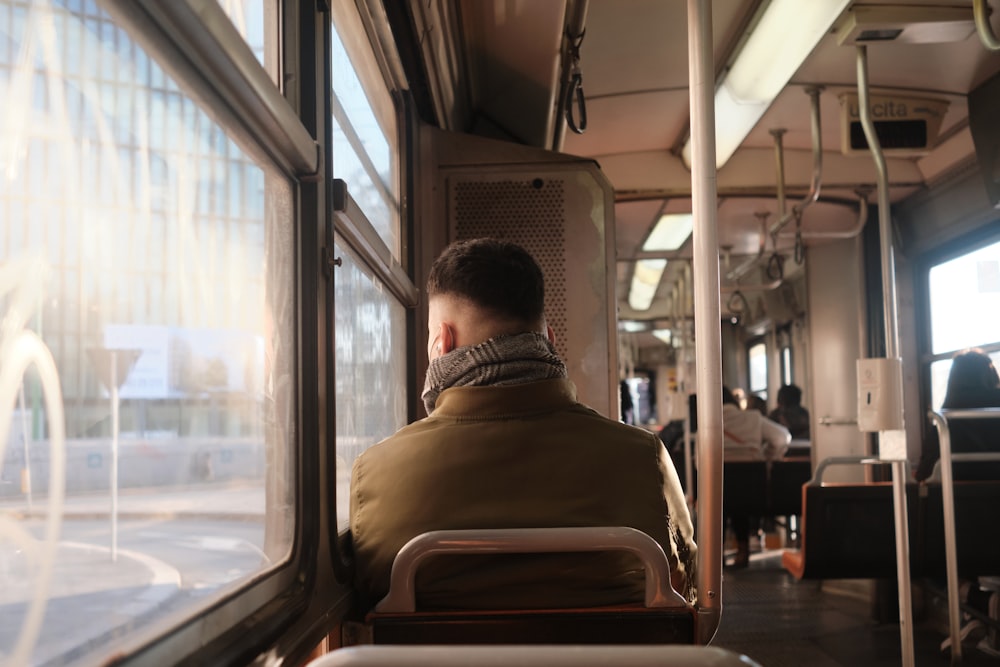 a man sitting on a bus looking out the window