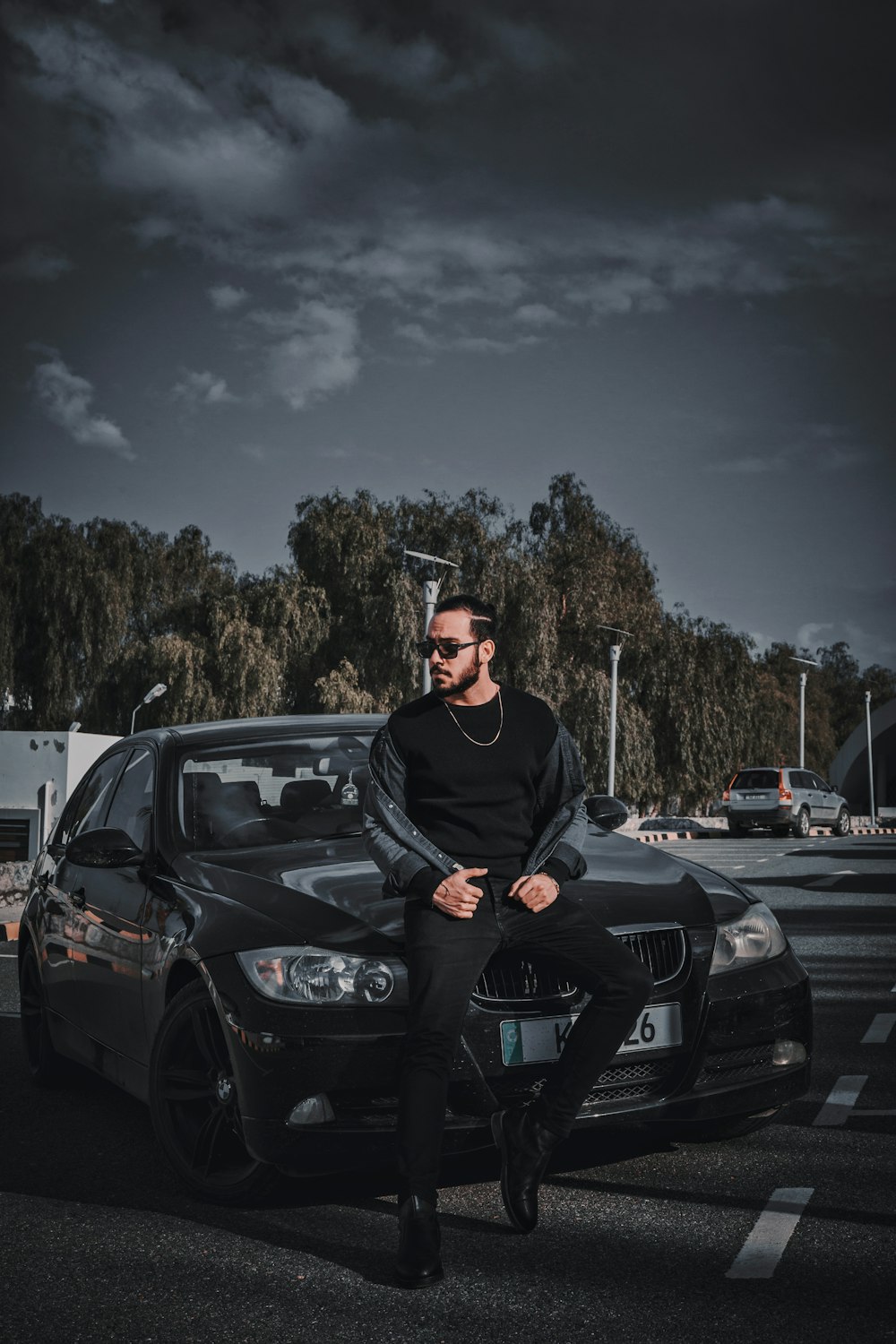 a man sitting on the hood of a car