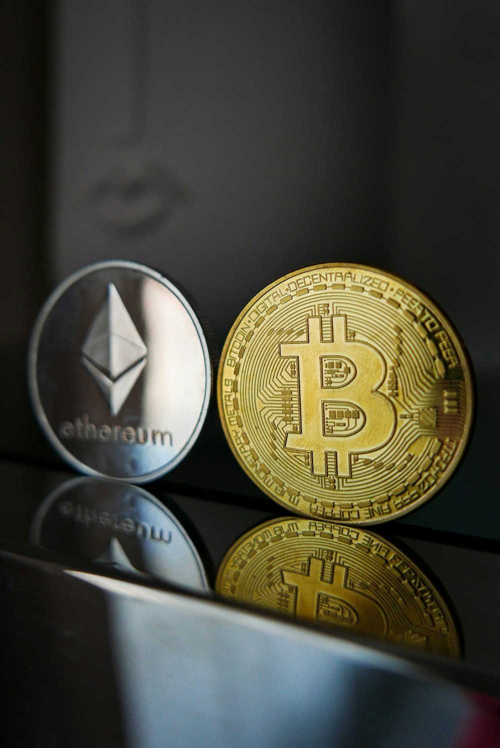 Una moneda de Bitcoin y Ether sentada una al lado de la otra