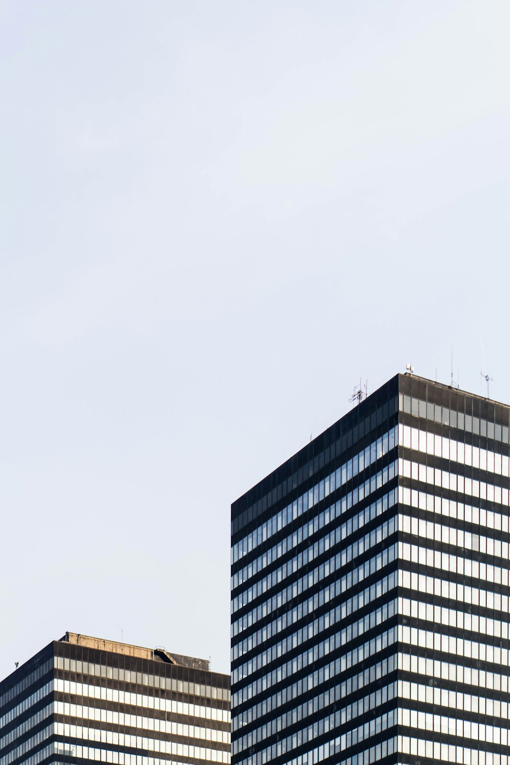 a plane flying in the sky over a building