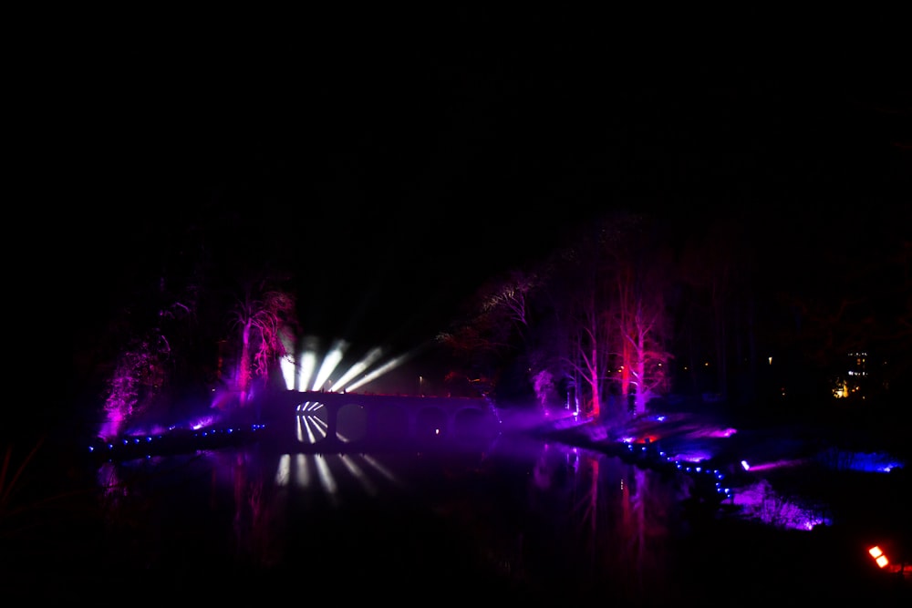 a pond with lights reflecting in it at night