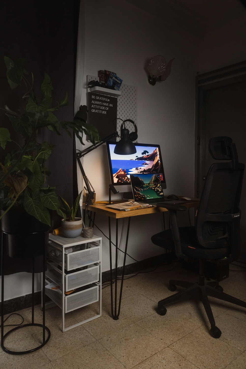 un bureau avec un ordinateur et une plante dessus