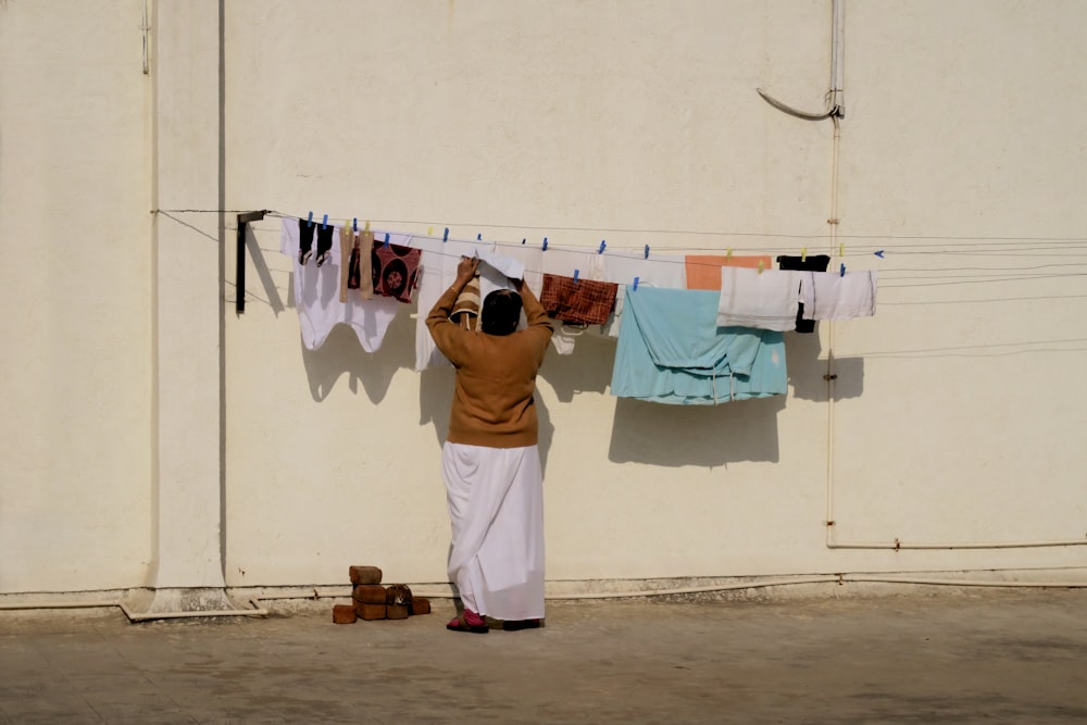 a woman hanging out her clothes on a clothes line