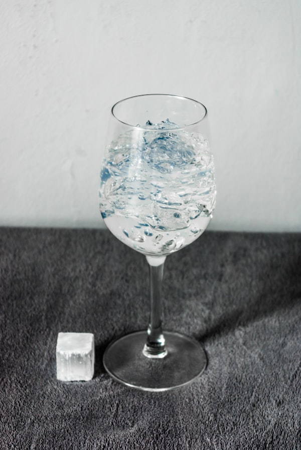 Glas mit Wasser und Eiswürfeln auf einem Tisch