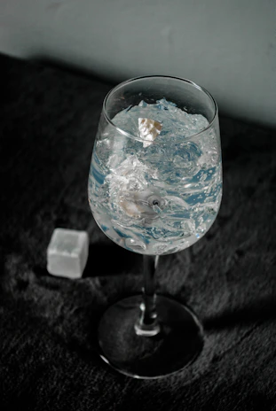 Happy customer holding a chilled glass with Vidama's premium ice cubes at a cozy home gathering.