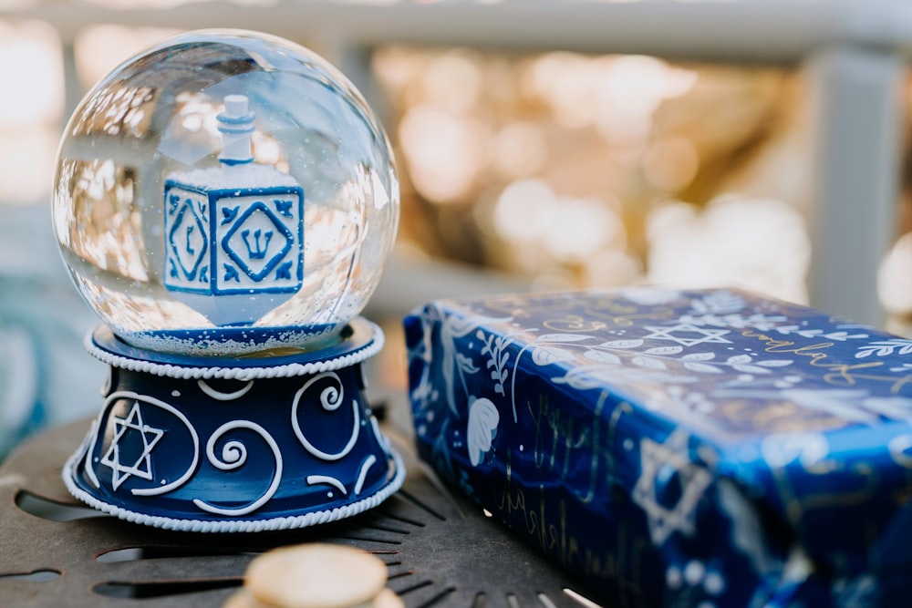 a snow globe sitting on top of a table next to a blue box