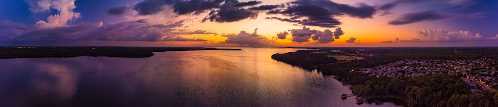 a sunset over a body of water with clouds in the sky