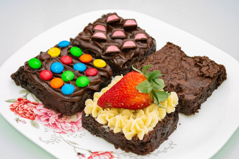 um prato branco coberto com brownies cobertos de doces