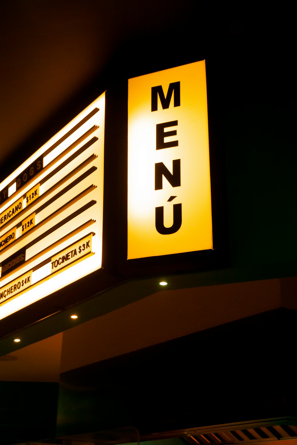 a menu sign is lit up in the dark