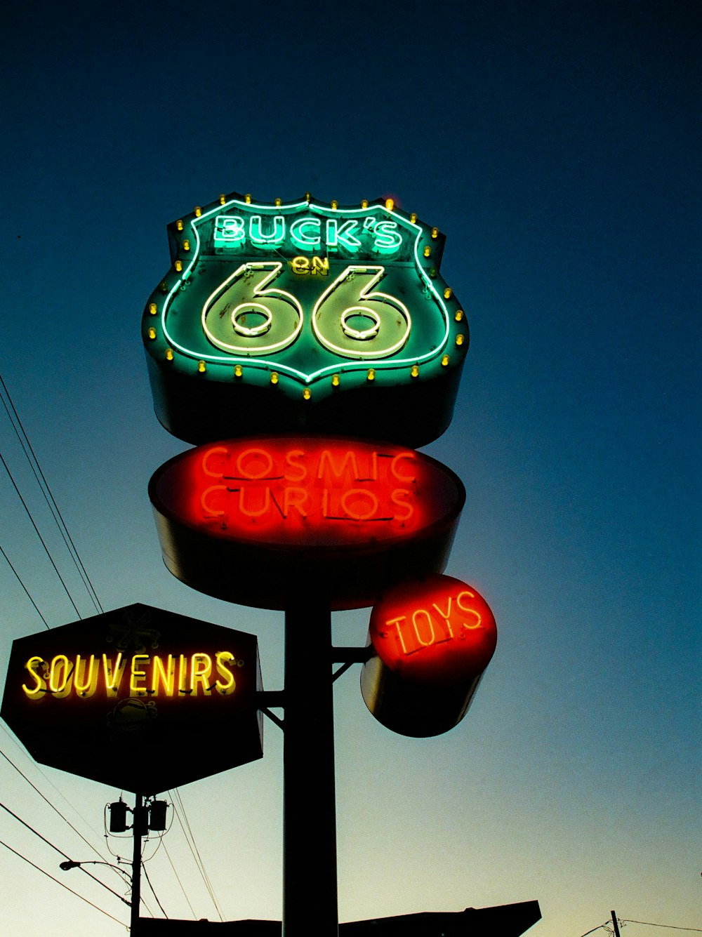 a neon sign for a toy store with a sky background