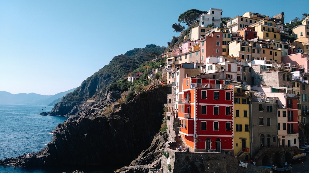 a group of buildings sitting on top of a cliff next to the ocean