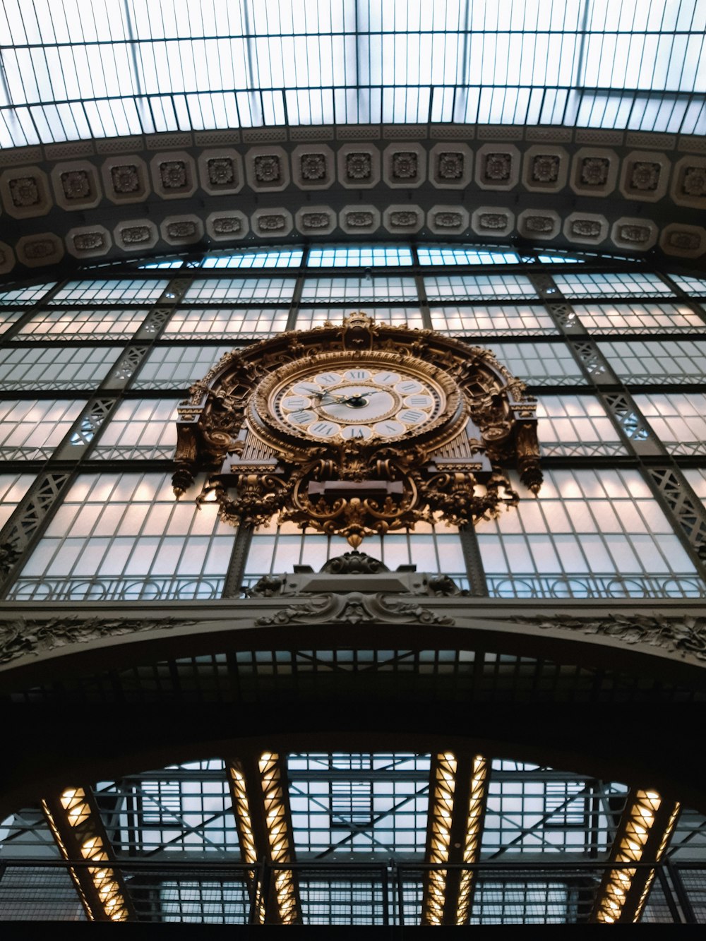 a clock mounted to the ceiling of a train station