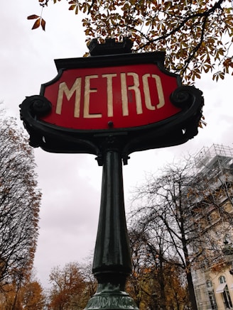 a red metro sign sitting on top of a metal pole