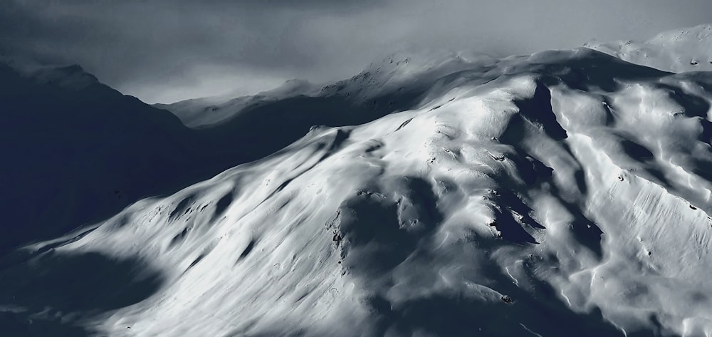 a mountain covered in snow under a cloudy sky