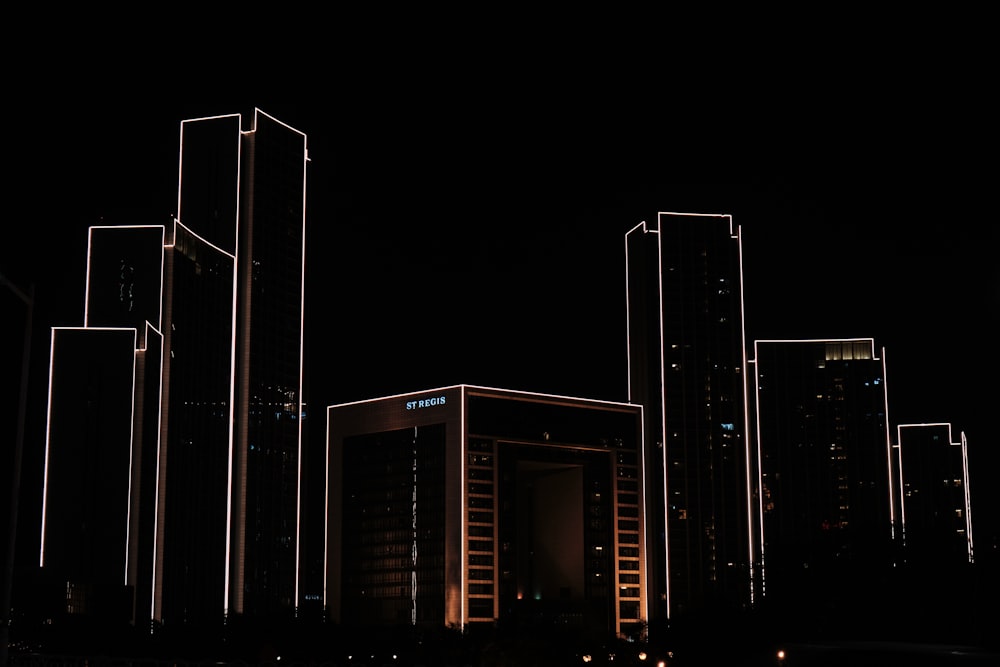 a city at night with tall buildings lit up