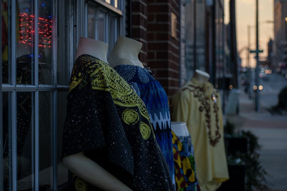 a row of mannequins in front of a store window