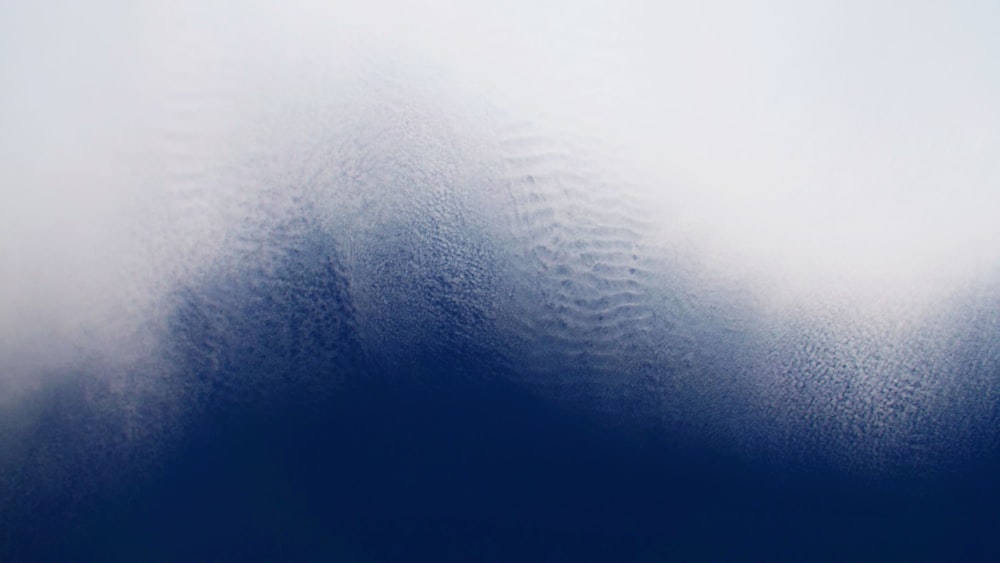 a blue and white photo of clouds and water