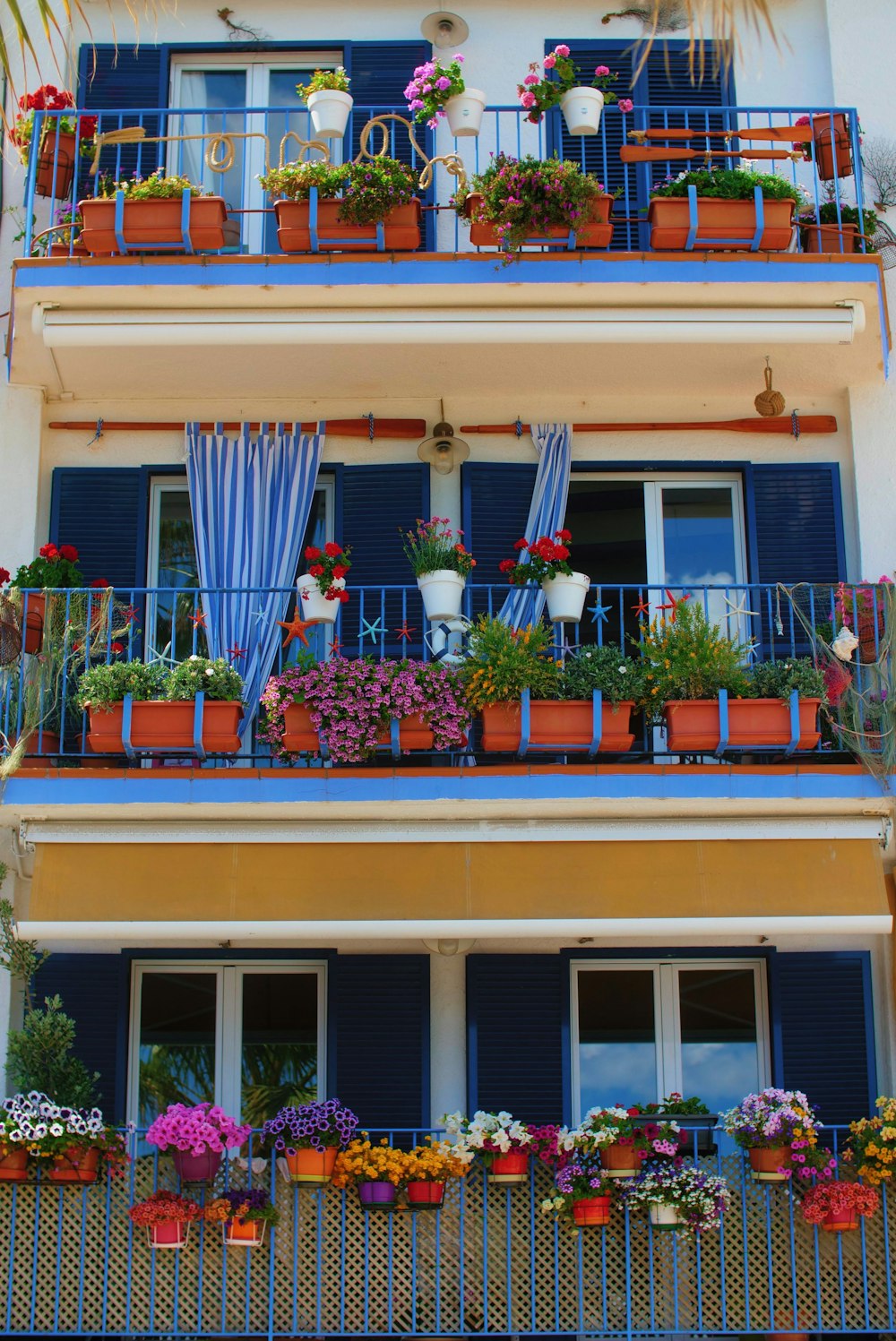 an apartment building with a balcony filled with potted plants