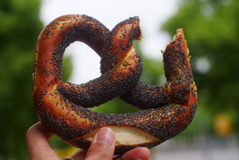 a person holding a pretzel in their hand