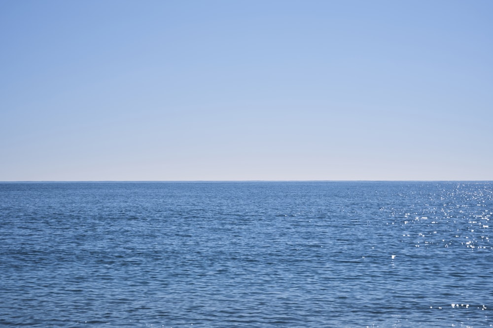 a large body of water sitting under a blue sky