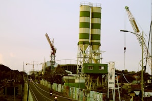 a large green and white tower next to a road