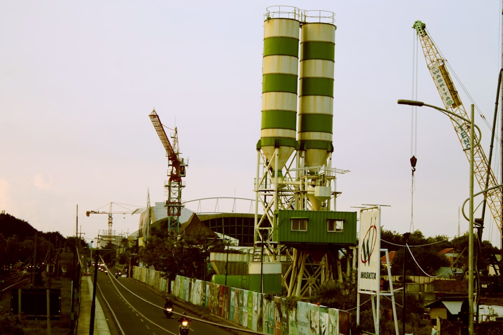 uma grande torre verde e branca ao lado de uma estrada