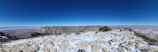 A panoramic shot capturing the vast landscape and distant mountains from the summit.