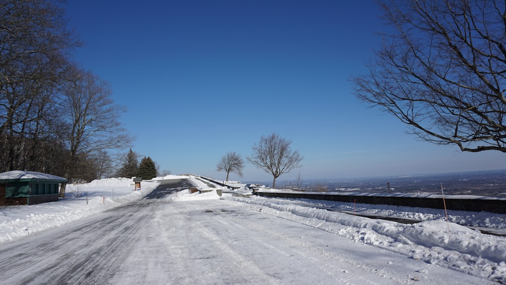 a road that is covered in snow with trees in the background