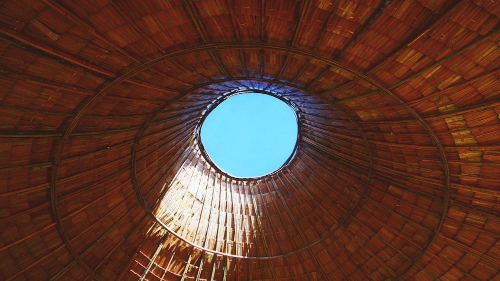 a round wooden structure with a blue sky in the background