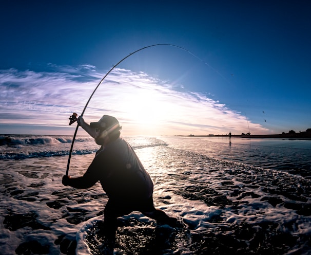 a person standing in the water with a fishing pole