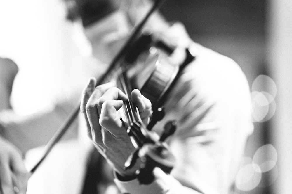 a black and white photo of a man playing a violin