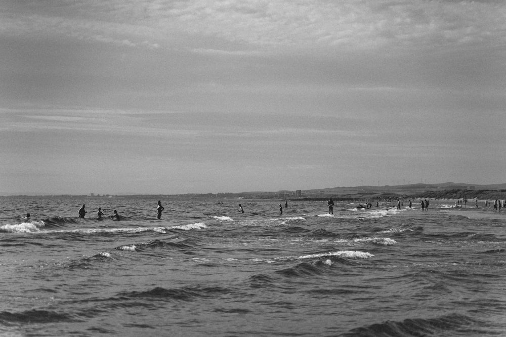a black and white photo of people in the ocean