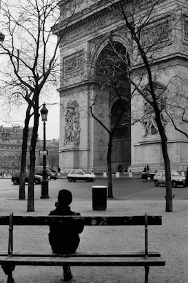 a person sitting on a bench in front of a building