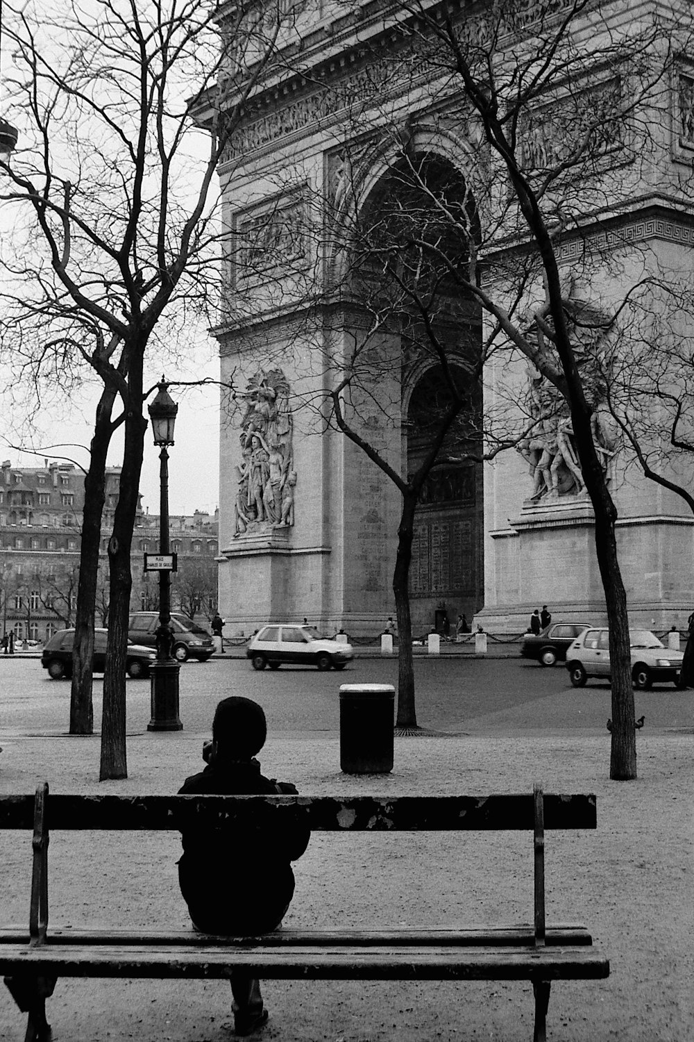 a person sitting on a bench in front of a building