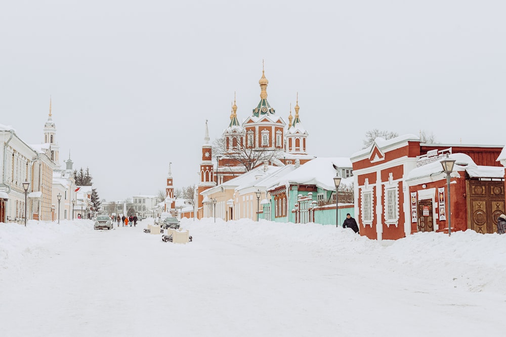 a snow covered street with a church in the background