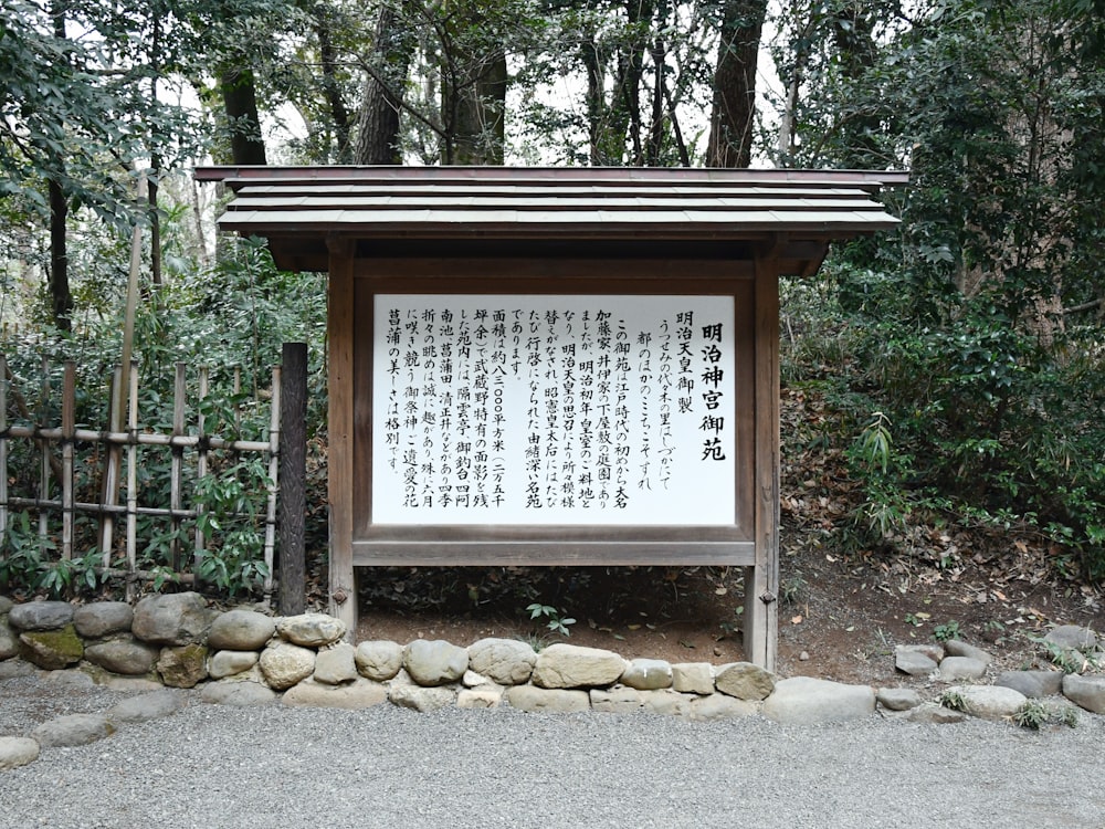 a sign in front of some rocks and trees