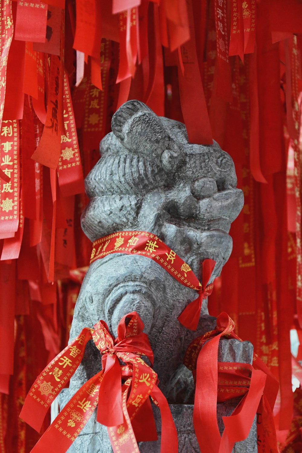 a statue of a lion with a red ribbon around its neck
