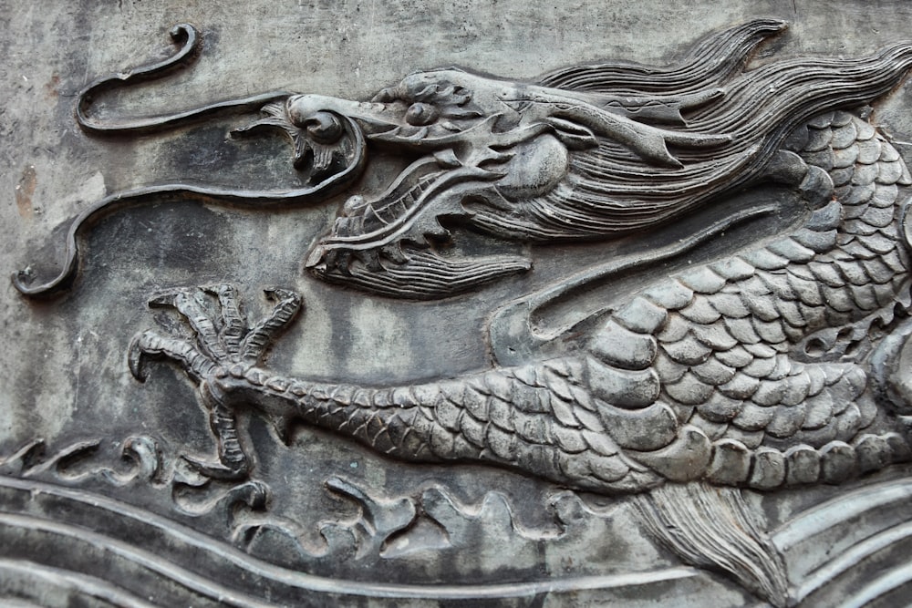 a close up of a dragon carving on a wall