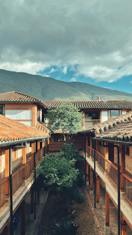 Vista exterior de la casa Carmen de Salazar con su jardín y la Alhambra al fondo al atardecer.