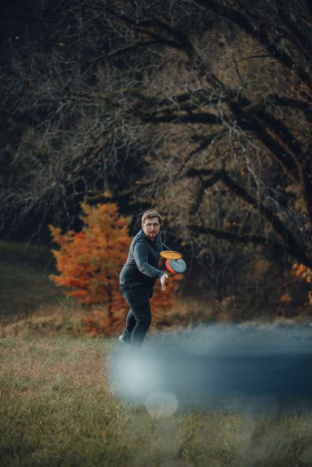 Ein Mann wirft einen Frisbee auf ein Feld