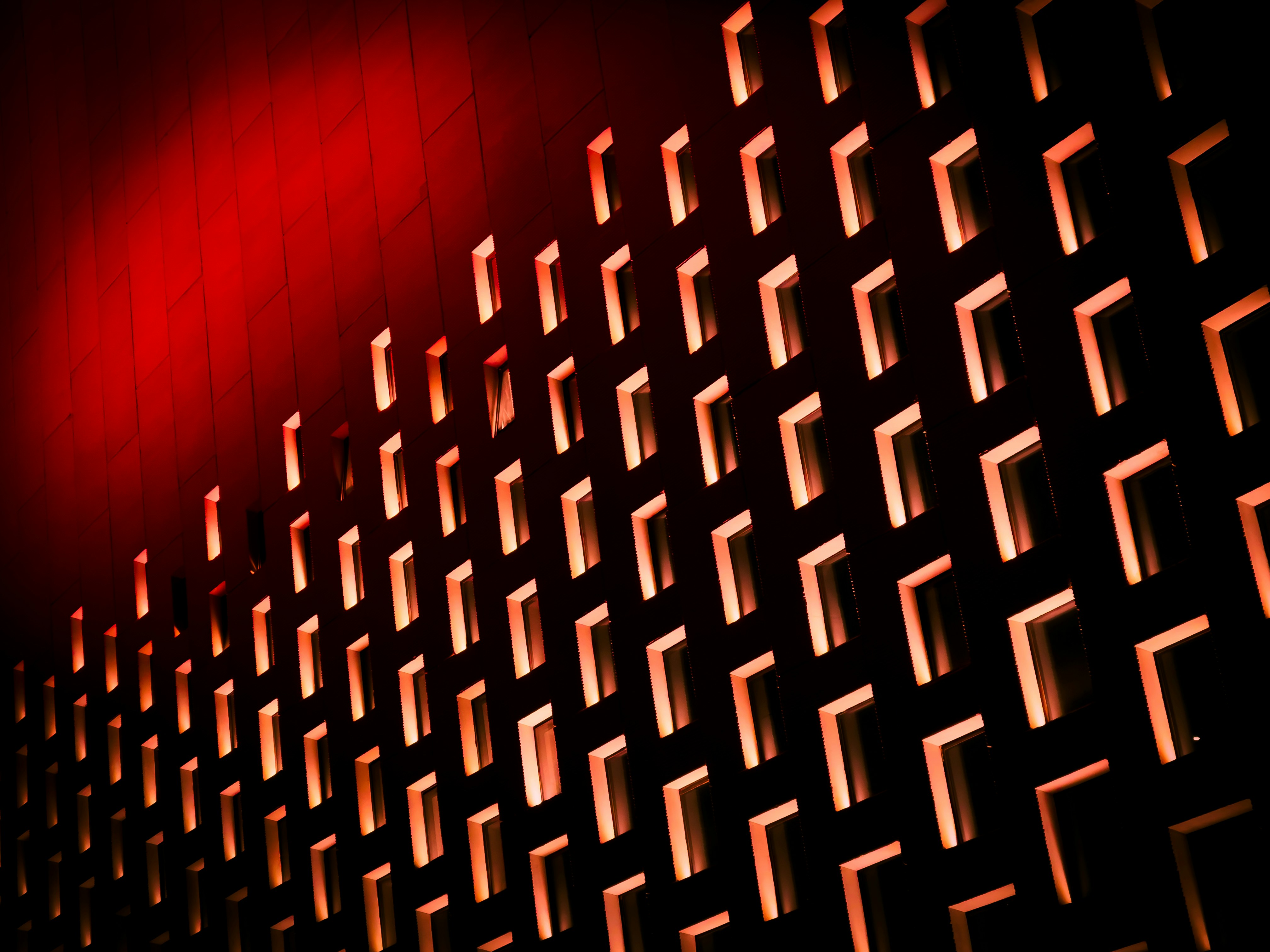 a red light shines on the side of a building