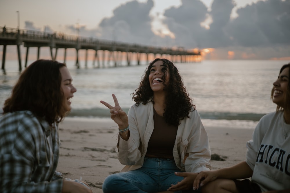 a group of women sitting on top of a beach